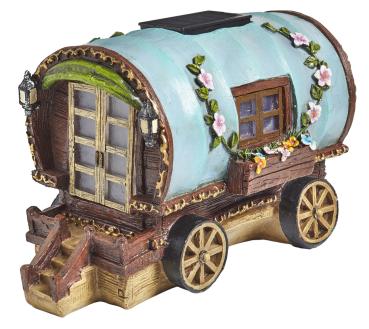 Ein kleines Feenhaus in Form eines Campingwagens vor weißem Hintergrund.